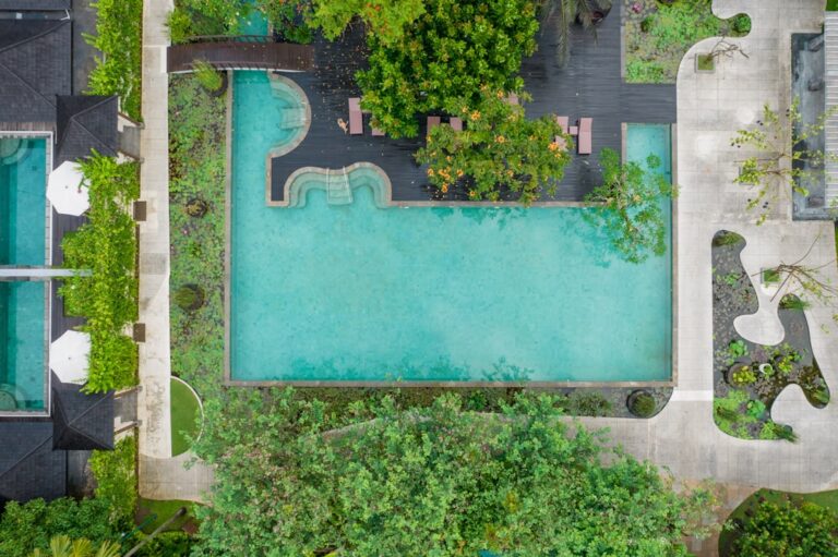 Vista Aerea De Uma Piscina Cercada Por Arvores 2AV7T1hTkNM