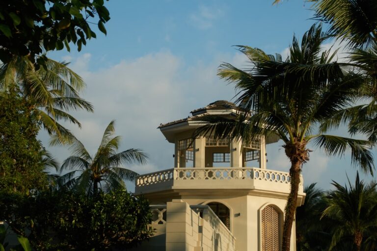 Uma Torre Com Palmeiras Contra Um Ceu Azul F37I4xZunJ4