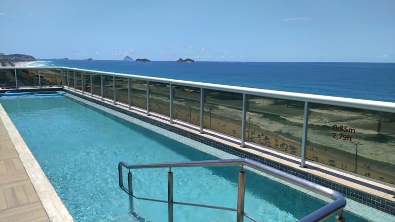 Uma Piscina Com Um Edificio Ao Fundo UkQOhXIWWkU