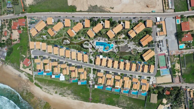 Drone shot of a residential complex by the beach in Taiba, Brazil, highlighting modern architecture.