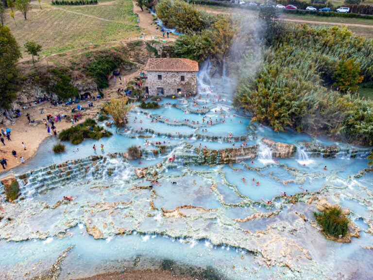 Stunning aerial photo of Saturnia Hot Springs with turquoise waters and natural limestone terraces.