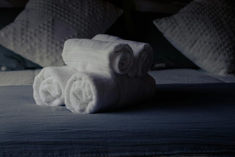 Inviting hotel room scene with neatly folded towels on bed.